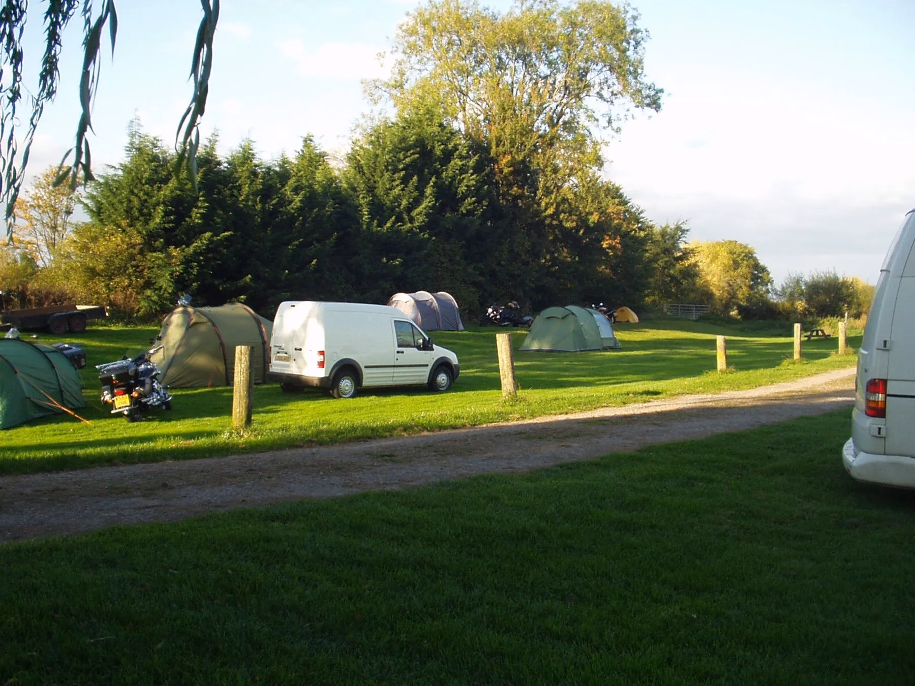Tents and small camper vans spaced across the Lower Lode's grass camping field.