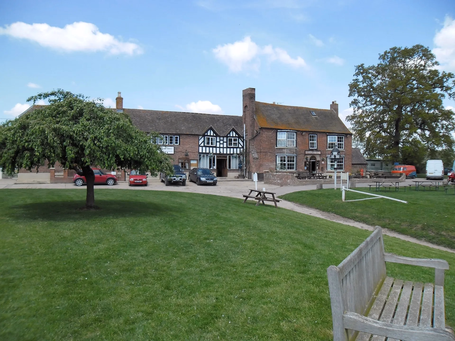 The historic brick-and-timber Lower Lode Inn viewed across its lawn.