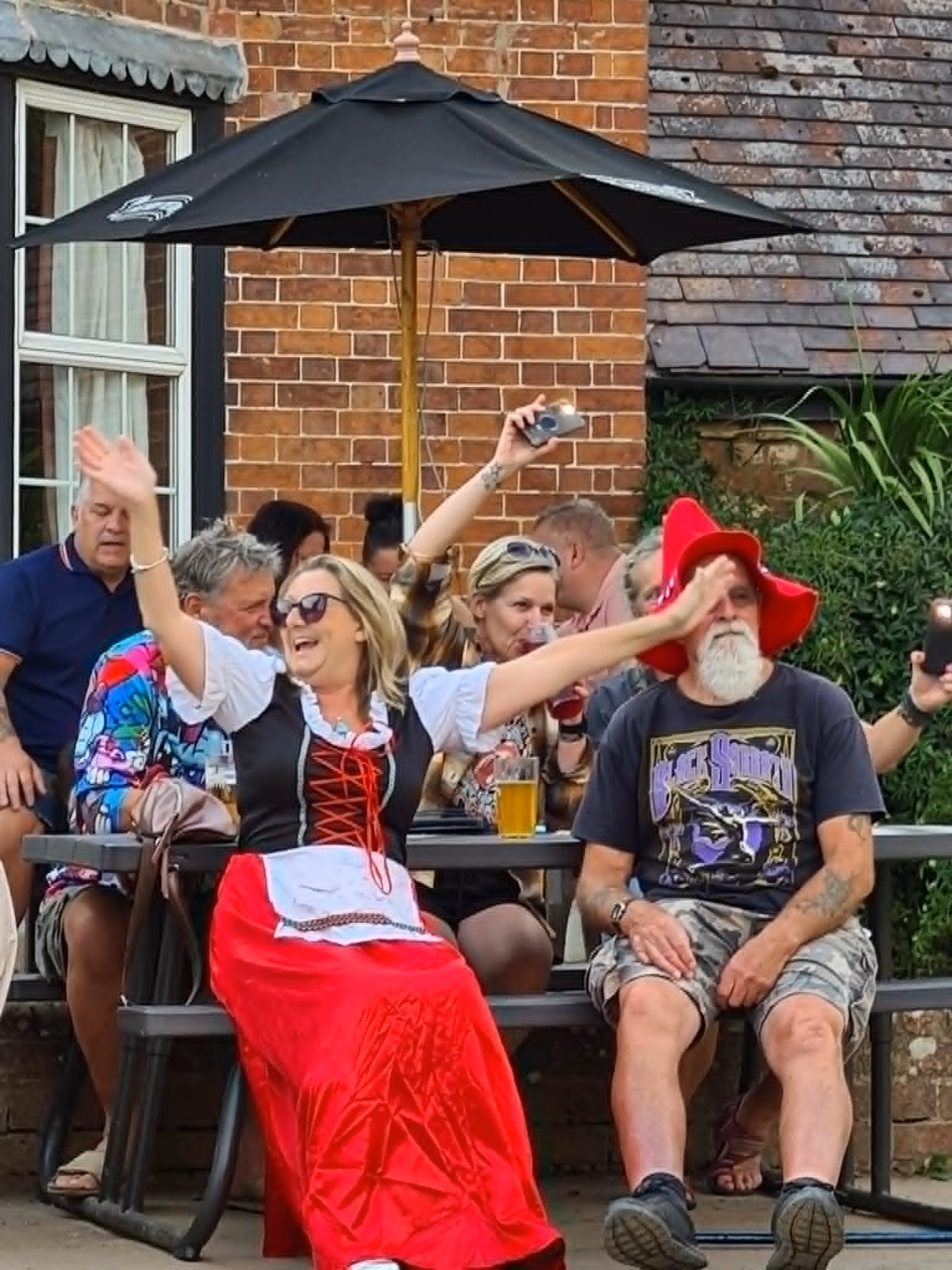 A visitor in Bavarian-style dress dancing with raised arms outside the Lower Lode Inn.