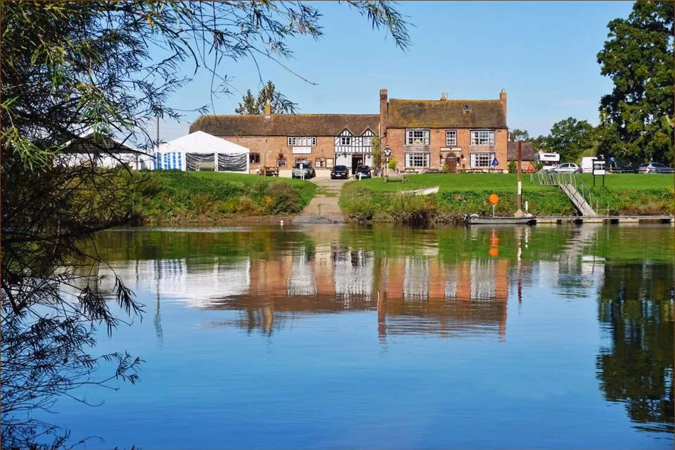 The Lower Lode Inn reflected in the River Severn, viewed from the opposite bank.